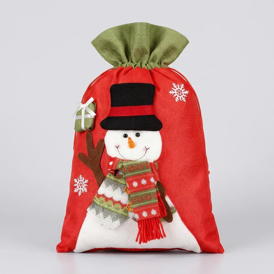 Red Christmas gift bag with a snowman design, featuring a black top hat and a festive scarf.