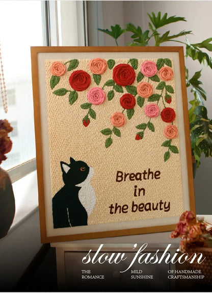 Punch needle kit featuring a black and white cat and pink and red roses with text.