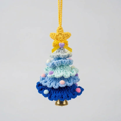 Crocheted gradient blue Christmas tree ornament with a yellow star topper and gold bell.