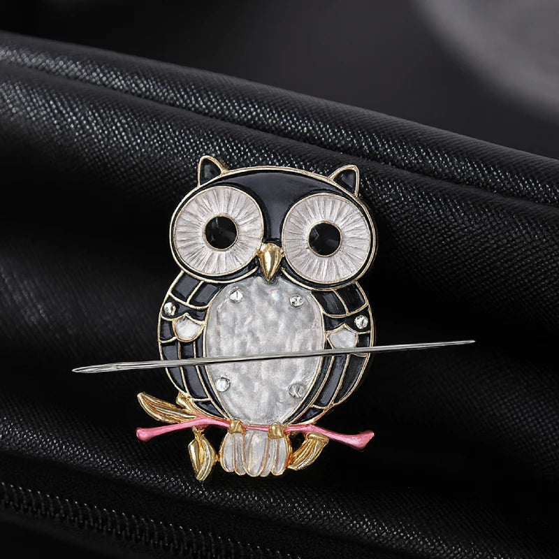 Decorative owl brooch with gemstones on a black background