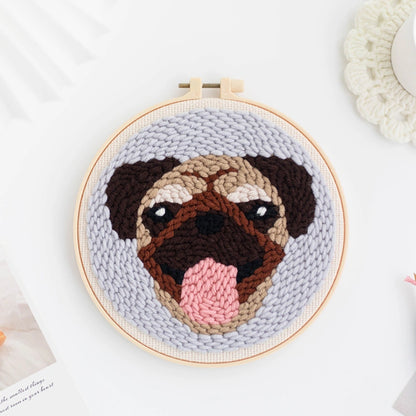 Punch Needle hoop with a pug dog face design on a light gray background