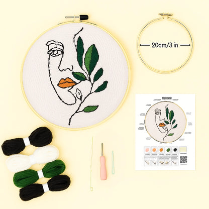Embroidery kit with hoop, thread, needle, and color chart on a light yellow background