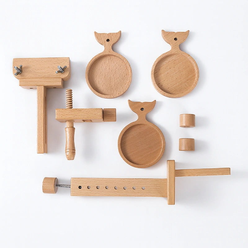 Set of wooden kitchen tools including a press, bowls, and other utensils on a white background
