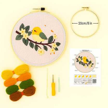 Embroidery hoop with pre-printed pattern, colorful yarn, needle, and instruction sheet on a light yellow background