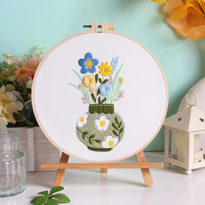 Spring Vase captures the gentle charm of blooming flowers in a simple green vase — a celebration of new beginnings and quiet beauty. The soothing mix of blue, yellow, and mint green threads brings a fresh, elegant touch to your home décor, perfect for brightening up any space.