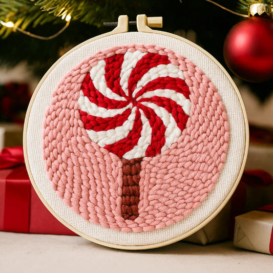 A red and white candy swirl on a pink background, symbolising the sweetness and joy of Christmas.