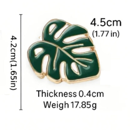 Green leaf-shaped pin with measurements on a white background