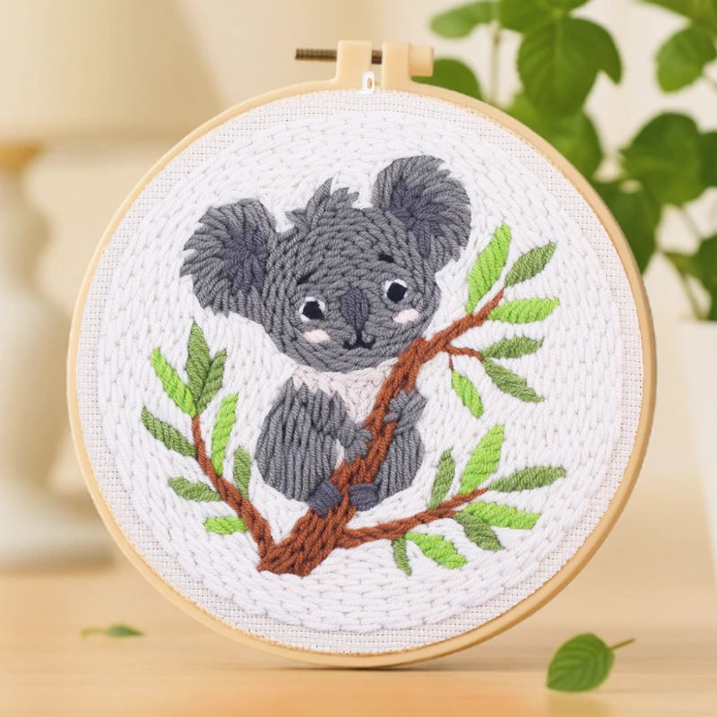 This lovely embroidery design features a playful koala clinging to a leafy tree branch. Its gentle expression and soft color palette of grey, green, and brown bring warmth and charm to any space. Simple to create and beginner-friendly, it’s a perfect project for relaxing weekends or as a thoughtful handmade gift.