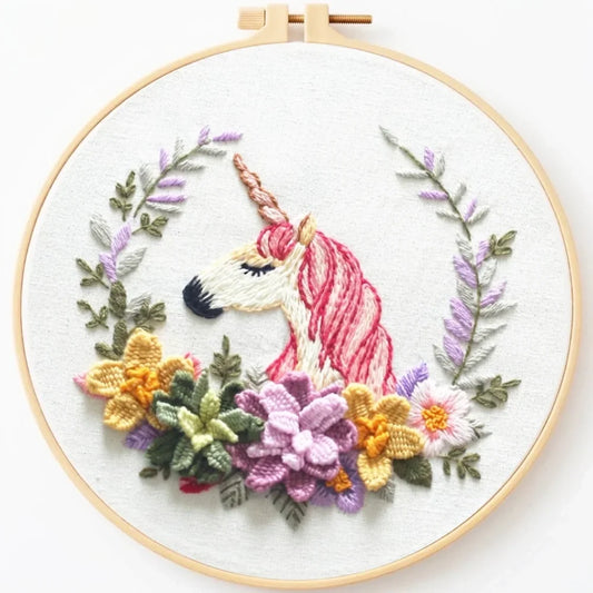 Handmade embroidery hoop art featuring a unicorn head surrounded by colorful floral wreath.