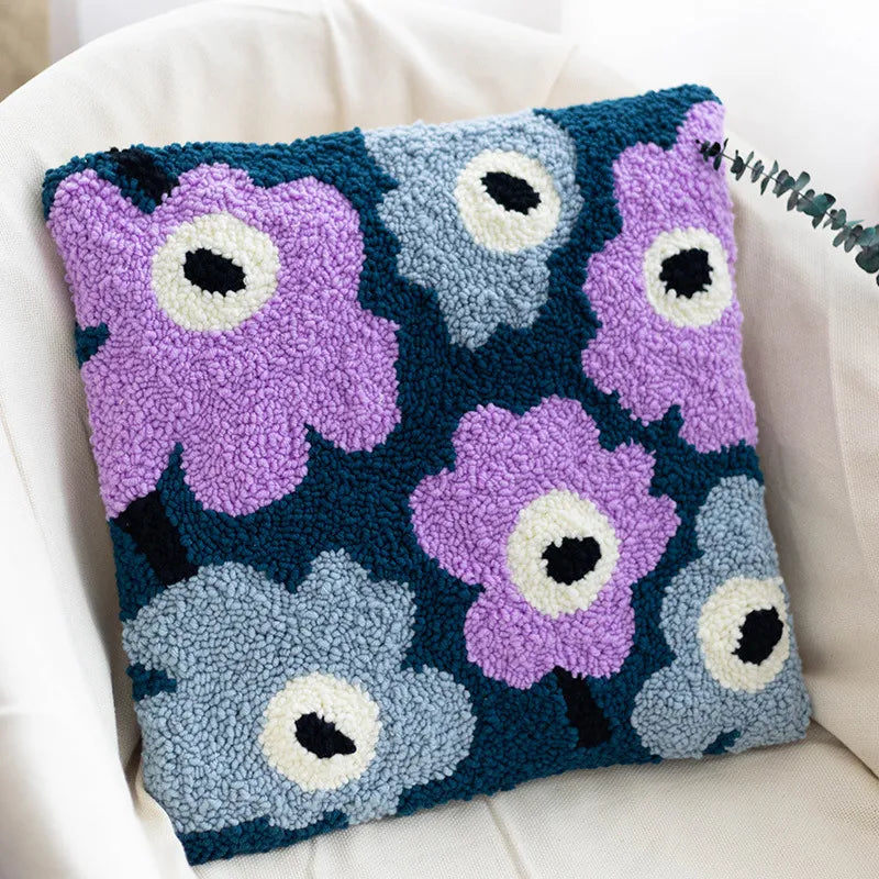 Floral-patterned pillow with purple and blue flowers on a white couch