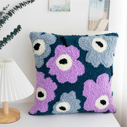 A punch needle pillow cover featuring dreamy violet and grey flowers on a deep teal background. The fresh yet elegant color palette adds a cozy, artistic touch to your home decor.