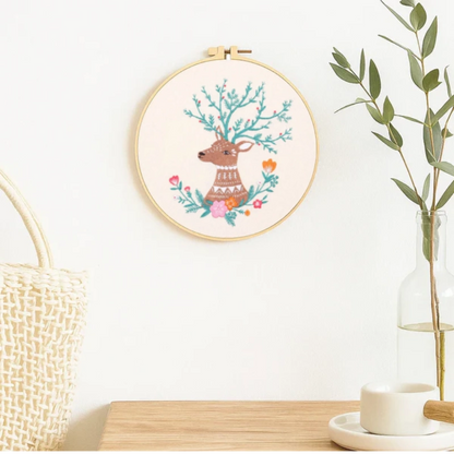 This embroidery piece features a gentle deer with branch-like antlers adorned with delicate flowers and leaves. The soft color palette creates a warm, soothing atmosphere, making it a perfect decorative piece to bring a touch of woodland serenity into your home.