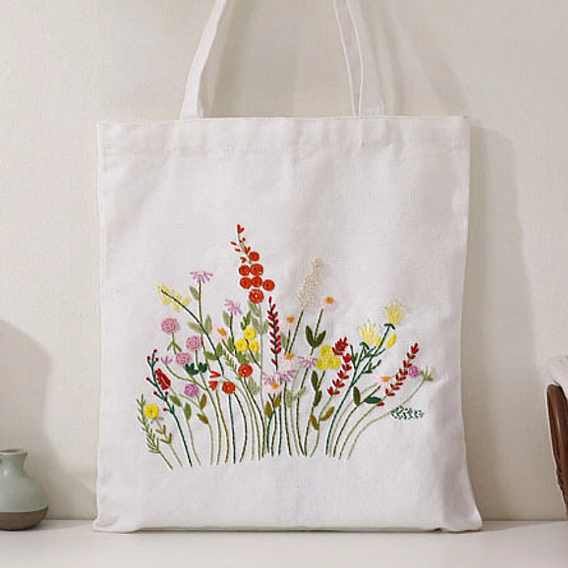 White tote bag with floral embroidery on a neutral background