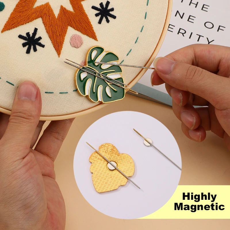 Person using a needle to work on an embroidery project with a decorative leaf design.