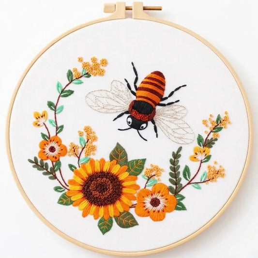Embroidered bee and sunflower floral wreath in a wooden embroidery hoop