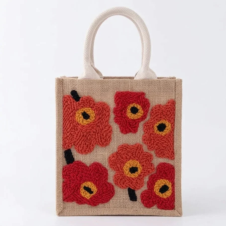 Handcrafted jute tote bag featuring red embroidered poppy flowers