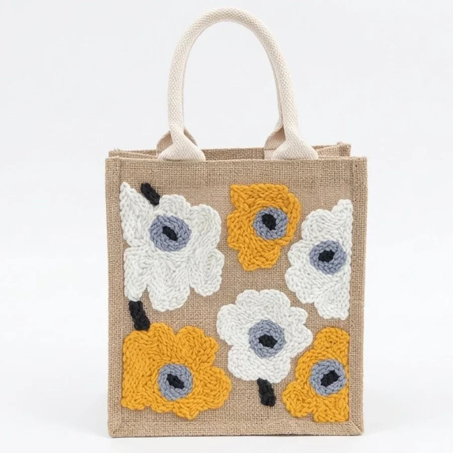 Small jute tote bag with colorful embroidered floral patterns and white handles