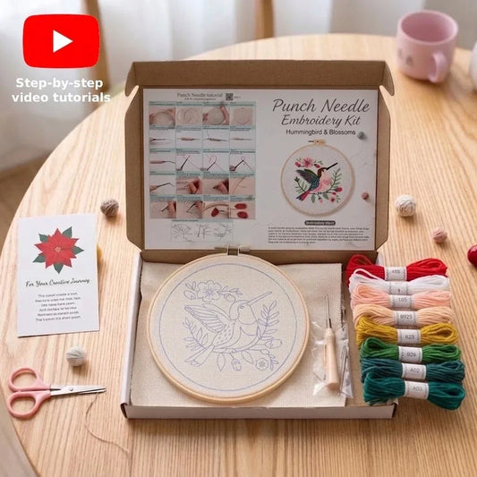 Punch needle embroidery kit with hummingbird pattern, colorful threads, and tools.