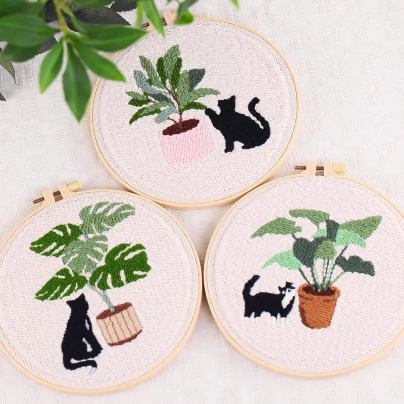 Three Punch Needle hoops featuring black cats and potted green plants.