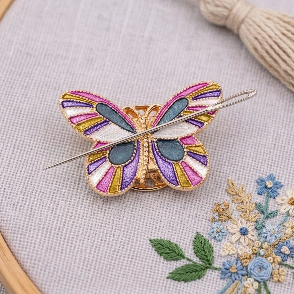 Calivra Craft butterfly magnetic needle minder in pink, purple, and teal on grey fabric