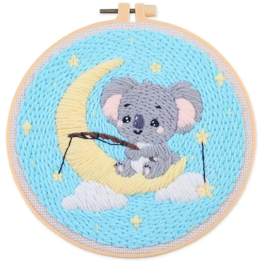 punch needle koala sitting on a crescent moon with stars on a blue background hoop art