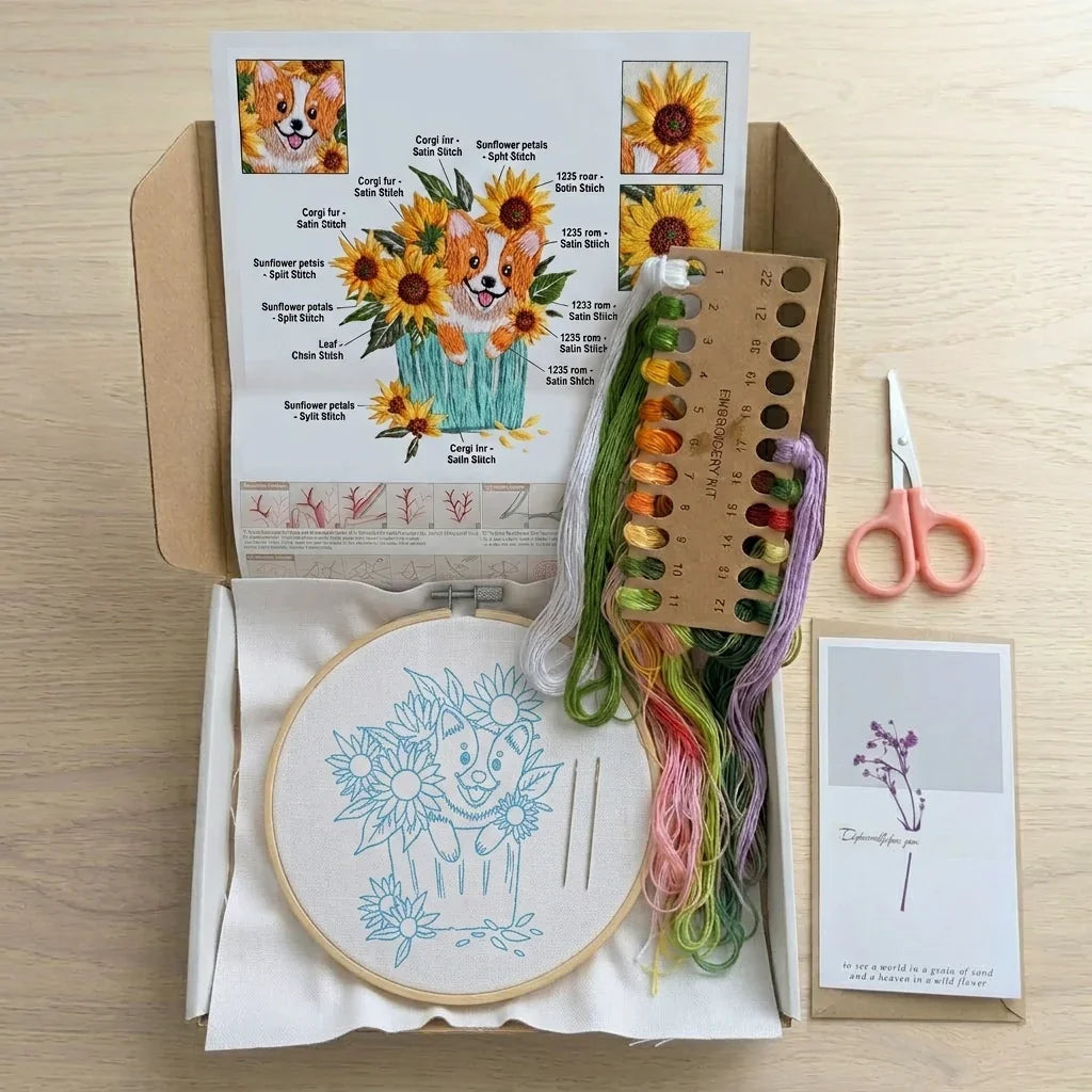Embroidery kit with corgi and sunflower pattern, colorful floss, hoop, and scissors.