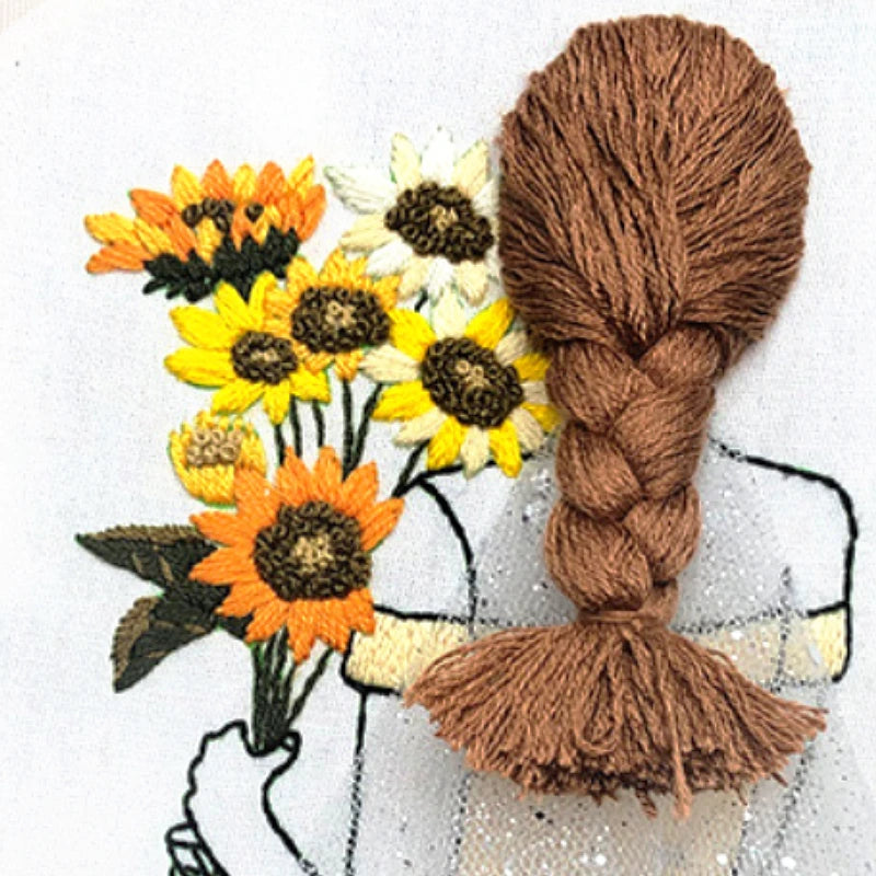 Yarn braid next to embroidered sunflowers on a white background