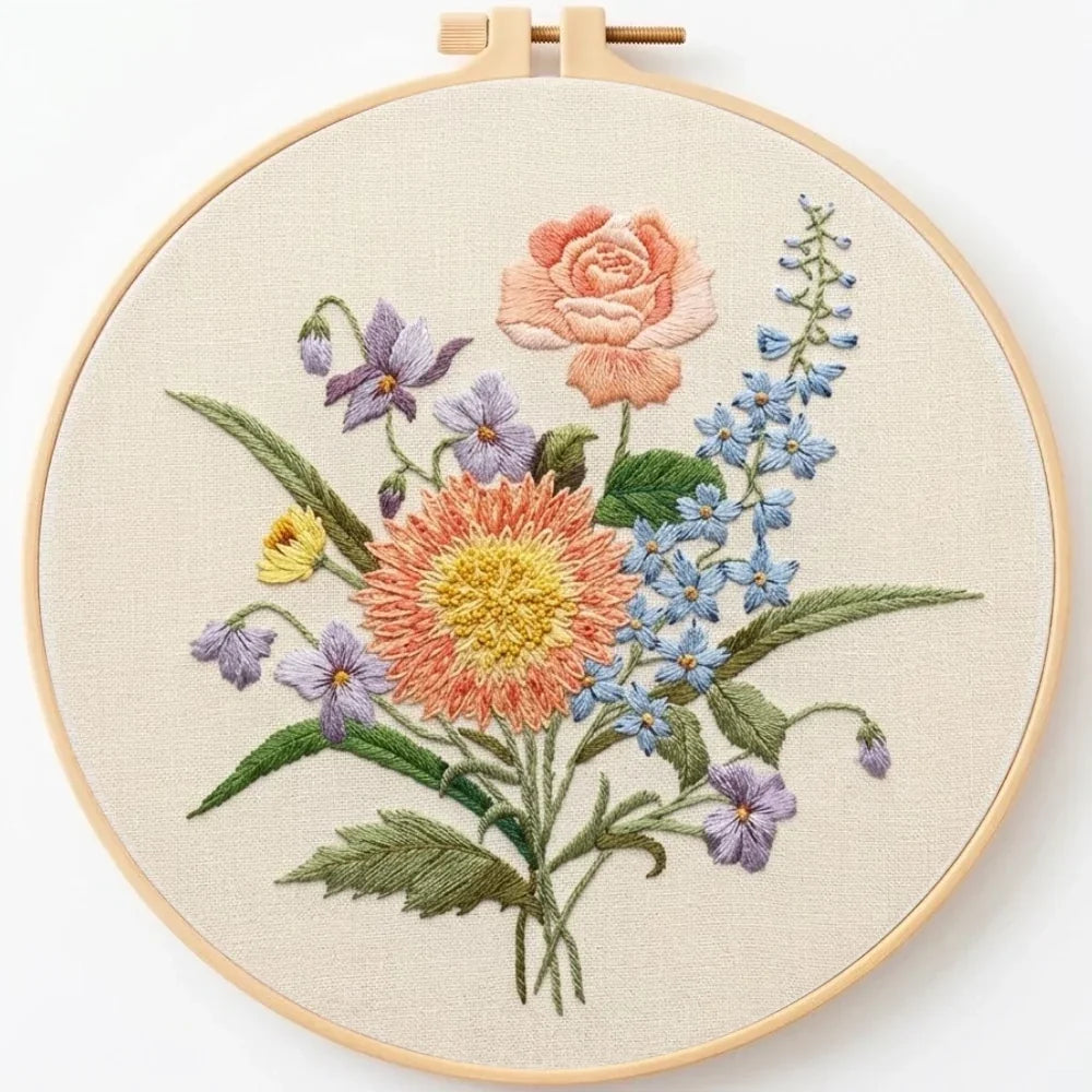 Hand-embroidered floral bouquet in a wooden embroidery hoop on off-white fabric.