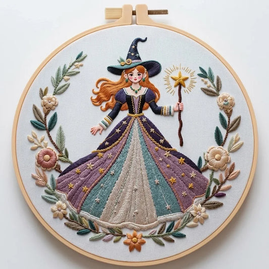 Hand embroidery of a whimsical witch in a purple gown holding a magic wand, framed by floral motifs.
