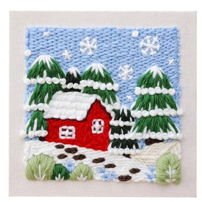DIY punch needle embroidery kit featuring a red house and snowy pine trees scene.
