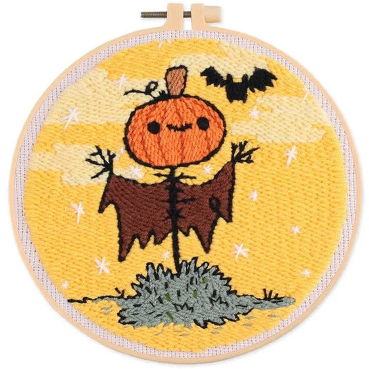 Punch needle Halloween pumpkin scarecrow with a bat on a yellow background in a hoop.