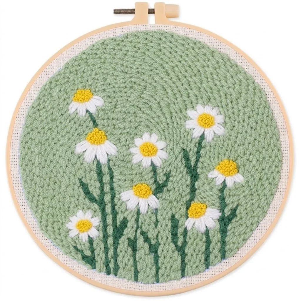 Hand embroidery hoop art featuring white daisies with yellow centers on a green textured background.