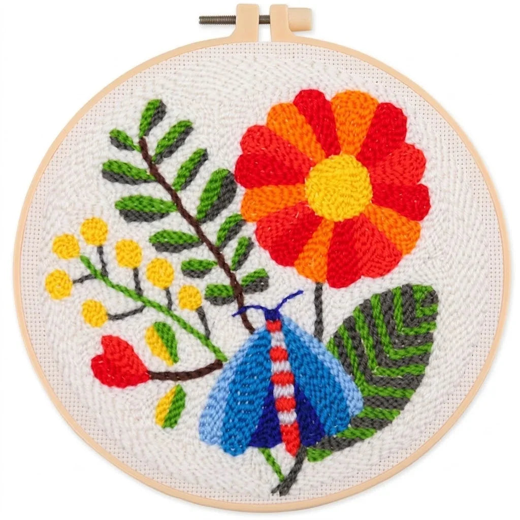 Hand embroidery of a colorful red flower, blue butterfly, and green leaves in a wooden hoop.