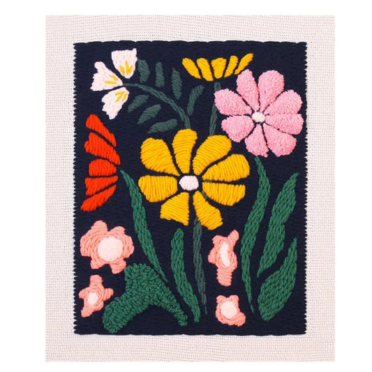 Colorful punch needle floral pattern with yellow, pink, and red flowers on a dark navy background.