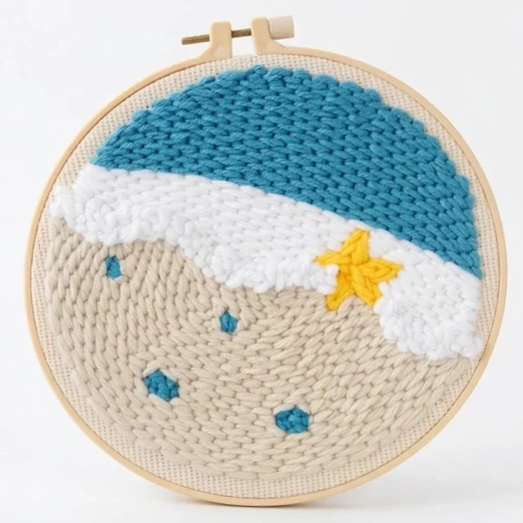 Punch needle hoop featuring a textured beach scene with blue ocean waves and a yellow starfish.