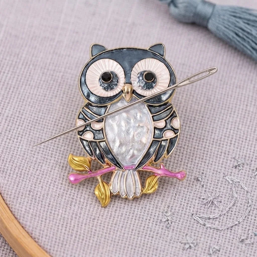 Calivra Craft owl magnetic needle minder holding a sewing needle on grey fabric