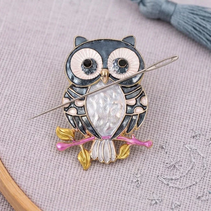 Calivra Craft owl magnetic needle minder holding a sewing needle on grey fabric